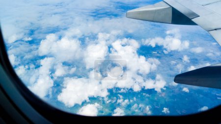 Téléchargez les photos : Magnifique vue sur la nature du ciel de beauté et des nuages à travers une fenêtre d'avion. Concept de voyage. voyageur, voyage, vacances, tourisme - en image libre de droit