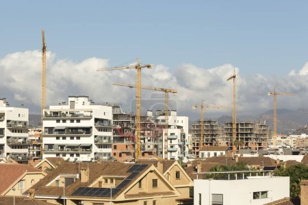 Photo for View of various cranes in a city, rooftops and buildings under construction. Speculation, industry. - Royalty Free Image