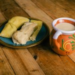 Tamales de elote and atole on a wooden table. Typical Mexican food.
