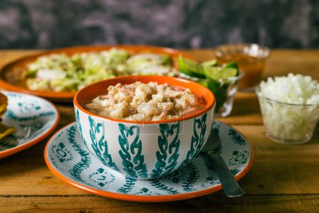 Téléchargez les photos : Pozole servi dans un plat profond, avec salsa et légumes sur une table en bois. Nourriture mexicaine typique. - en image libre de droit