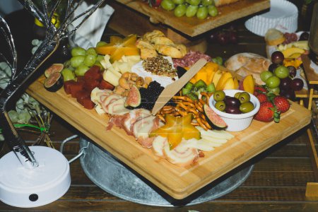 Cheese platter with fruits and cold meats during an evening celebration