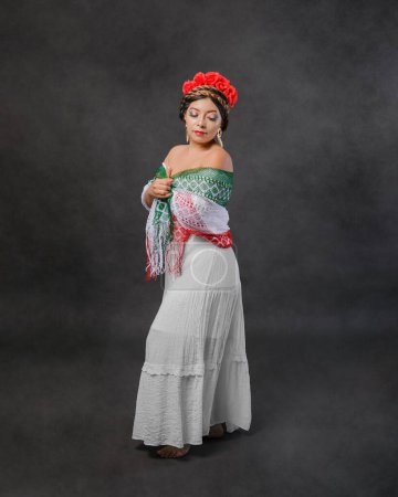 Mexican woman with white dress and tricolor scarf. Full length female portrait in studio of Mexican woman with scarf with the colors of the Mexican flag.