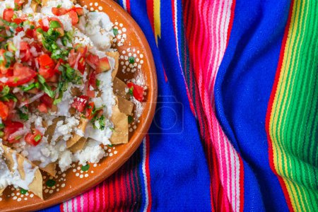 Photo for Nachos with cream cheese and pico de gallo on a colorful serape. - Royalty Free Image