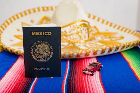 Photo for Mexican passport, mariachi hat and small car on colorful serape. Travel concept. - Royalty Free Image