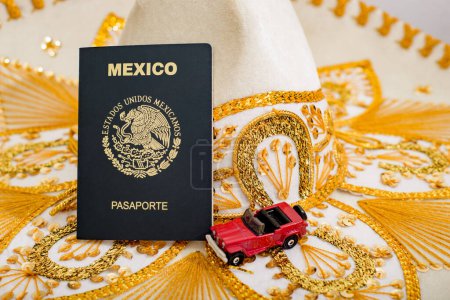 Photo for Mexican passport and and small car on charro hat. Mariachi hat and Mexican passport. Mexican citizenship concept. - Royalty Free Image