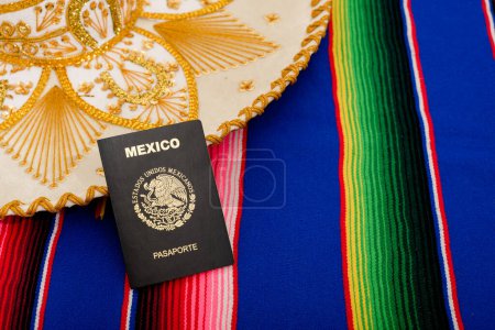 Photo for Mexican passport and mariachi hat on colorful serape. Concept of mexicanity. - Royalty Free Image