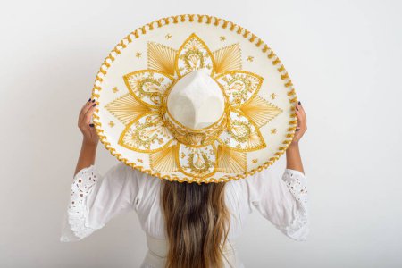 Photo for Portrait of woman from behind wearing mariachi hat. Woman with hat, white background. - Royalty Free Image