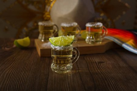 Photo for Tequila shots with salt and lime on a bar table. Shots of tequila and typical mexican elements. - Royalty Free Image