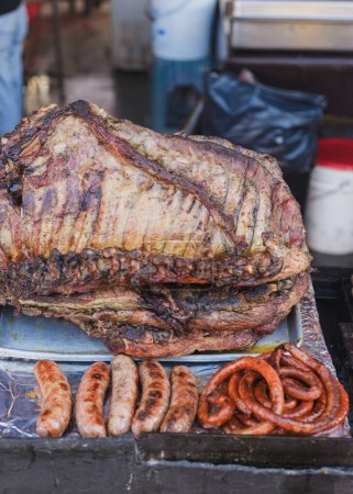 Person grillt Fleisch auf einem rustikalen Grill in Mexiko. Straßenstand mit Grillfleisch.
