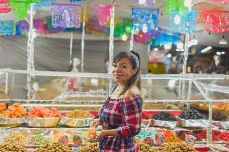Femme souriante avec un maïs bouilli à côté d'un stand de marché au Mexique.