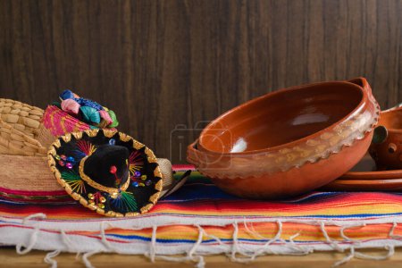 Clay pots, Mexican handicrafts and serape with wooden background. Cinco de mayo celebration background.