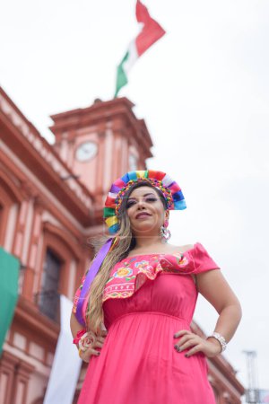 Femme mexicaine en robe traditionnelle. Rue décorée avec des couleurs du drapeau mexicain. Cinco de Mayo célébration.