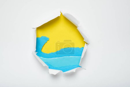 Photo for Hole in white paper showing a beach landscape created with torn paper. Colorful summer background. - Royalty Free Image