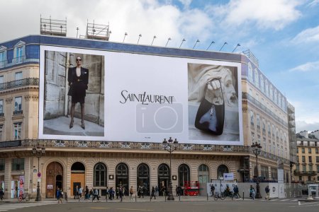 Foto de París, Francia - 31 de octubre de 2023: Yves Saint Laurent cartel publicitario gigante que cubre los andamios de las obras de restauración en la fachada de un edificio parisino - Imagen libre de derechos