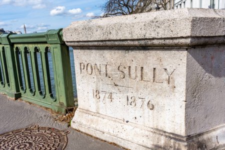 Foto de París, Francia - 26 de marzo de 2024: Inscripción en una piedra del parapeto del puente de Sully con las fechas de construcción. El puente Sully (también conocido como Pont de Sully) es un puente que cruza el río Sena. - Imagen libre de derechos