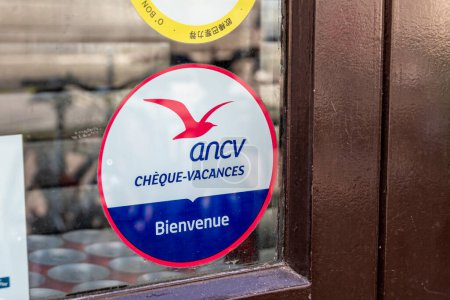Foto de París, Francia - 26 de marzo de 2024: Adhesivo en una ventana de negocio que indica que este establecimiento acepta el pago con cheques de vacaciones de la agencia francesa ANCV - Imagen libre de derechos