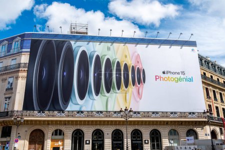 Foto de París, Francia - 31 de marzo de 2024: Apple iPhone 15 cartel publicitario gigante que cubre el andamiaje de los trabajos de restauración en la fachada de un edificio parisino que alberga una tienda Apple - Imagen libre de derechos