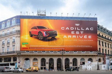 Foto de París, Francia - 14 de mayo de 2024: Cartelera publicitaria gigante escrita en francés para el automóvil eléctrico Cadillac Lyriq que cubre los andamios de las obras de restauración de un edificio parisino - Imagen libre de derechos