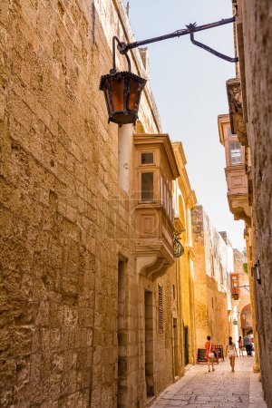 Téléchargez les photos : Mdina, Malte - 20 Juin, 2023 : Touristes marchant dans les ruelles de Mdina à Malte - en image libre de droit
