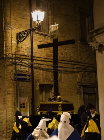 Téléchargez les photos : Chieti, Italie - 29 Mars 2024 : Pénitents à capuchon lors de la célèbre procession du Vendredi Saint à Chieti (Italie) portent la croix avec l'inscription INRI - en image libre de droit