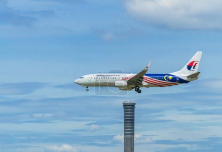 Téléchargez les photos : Samut Prakan, Thaïlande : 16 septembre 2023 : La compagnie aérienne malaisienne atterrit à l'aéroport international de Suvarnabhumi avec un ciel bleu. - en image libre de droit