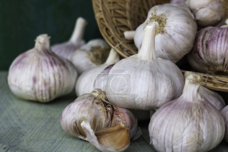 Photo for Many garlic bulbs in vintage baskets on wooden background. Healthy food. - Royalty Free Image