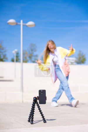 Photo for Teenage girl filming social media video, focus on the phone - Royalty Free Image