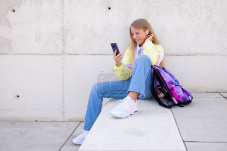 Photo for Teenage girl using mobile phone outdoors - Royalty Free Image