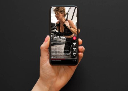 Photo for Video with a woman working out in a gym shared on social media app viewed on a mobile phone - Royalty Free Image