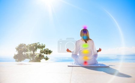 Woman meditating outdoors. Concept of seven energy chakras of the human body.