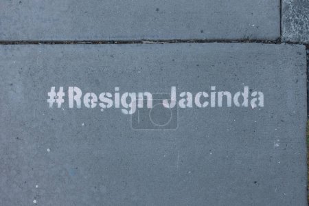 Photo for Stencilled lettering on a New Zealand pavement says '#Resign Jacinda' . Political statement slogan.Hashtag - Royalty Free Image