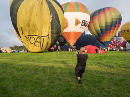 Photo for Bristol-UK-August 11 ,2023 - At Bristol Balloon Fiesta a man can be seen holding a rope tethering a balloon as it is inflated - Royalty Free Image