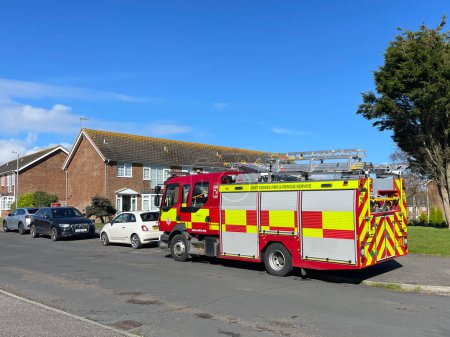 Téléchargez les photos : Bexhill-Sussex-UK-3 avril 2024- Un pompier stationné dans une rue résidentielle avec des logements et des arbres en arrière-plan. - en image libre de droit