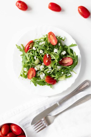 Grüner veganer Salat mit Rucolablättern und Kirschtomaten. Imbiss, Lebensmittel