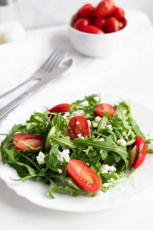 Ensalada vegana verde con hojas de rúcula y tomates cherry. Snack, comida