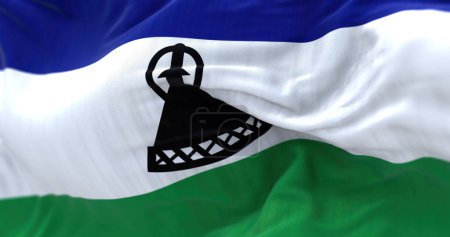 Foto de Vista de cerca de la bandera nacional de Lesotho ondeando. El Reino de Lesotho es un estado en el sur de África, uno de los tres reinos de África. Fondo texturizado de tela. Enfoque selectivo - Imagen libre de derechos
