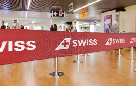 Photo for Zurich, CH, Feb 2023: Red barrier tape with the SWISS airlines logo inside an airport. SWISS is the national airline of Switzerland. Travel and airport security. Illustrative editorial - Royalty Free Image