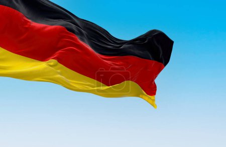 Die deutsche Nationalflagge weht an einem klaren Tag im Wind. Drei horizontale Bänder in schwarz, rot und gold. 3D Illustration rendern. Wellenförmiges Textil