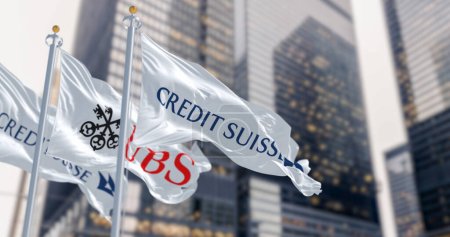 Photo for Zurich, CH, March 2023: Flags of Credit Suisse and UBS fluttering in the wind in a financial district. In March 2023, UBS bought Credit Suisse. Illustrative editorial 3d illustration render - Royalty Free Image