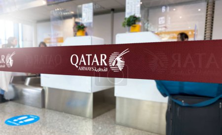 Photo for Doha, QA Jan 2023: Red barrier tape with the Qatar Airways logo inside an airport. Qatar Airways is a state-owned flag carrier airline of Qatar. Travel and airport security. Illustrative editorial - Royalty Free Image