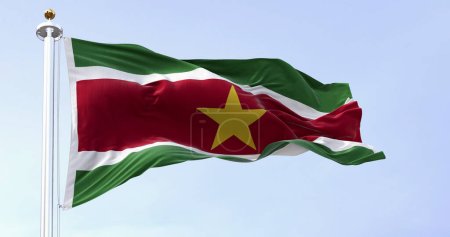 Die Nationalflagge Surinams weht an einem klaren Tag im Wind. 5 horizontale Bänder: grüner, weißer, roter, weißer, grüner, gelber Stern in der Mitte. 3D-Illustrationsrenderer. Flatterndes Textil