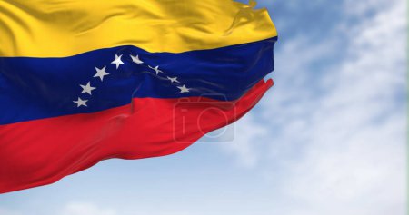 Téléchargez les photos : Drapeau national du Venezuela agitant dans le vent par temps clair. Tricolore jaune, bleu et rouge avec un arc de huit étoiles blanches à cinq branches au centre. illustration rendu. Tissu flottant - en image libre de droit