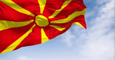 Photo for The national flag of North Macedonia that waving in the wind on a clear day. Stylized yellow sun with eight rays extending to the edges of a red field. 3d illustration render. Fluttering fabric. - Royalty Free Image