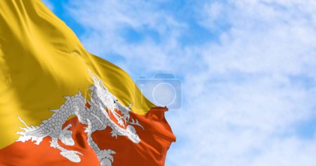 Photo for National flag of Bhutan waving in the wind on a clear day. Yellow upper triangle and an orange lower triangle, featuring a white dragon holding jewels in the center - Royalty Free Image
