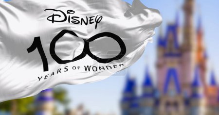 Téléchargez les photos : Orland, États-Unis, 10 octobre 2023 : Drapeau de célébration pour le 100e anniversaire de la Walt Disney Company agitant le vent. Illustration éditoriale 3d rendu - en image libre de droit