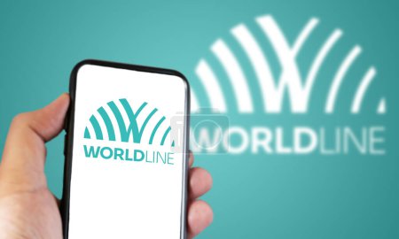 Photo for La Defense, FR, Oct. 15 2023: Hand holding a smartphone with the Worldline logo on the screen. Global leader in digital payment and transactional services. Illustrative editorial. Selective focus - Royalty Free Image