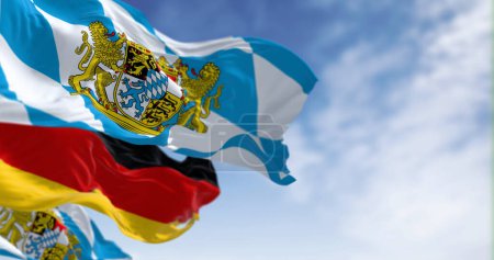 Banderas bávaras ondeando con bandera nacional alemana en un día claro. Baviera es un estado en el sureste de Alemania. 3d render ilustración. Enfoque selectivo. Tejido de aleteo.