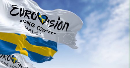 Téléchargez les photos : Malm, SE, 25 octobre 2023 : Concours Eurovision de la chanson 2024 et drapeaux suédois agitant par temps clair. L'édition 2024 aura lieu à Malmo en mai. Illustration éditoriale 3d rendu - en image libre de droit