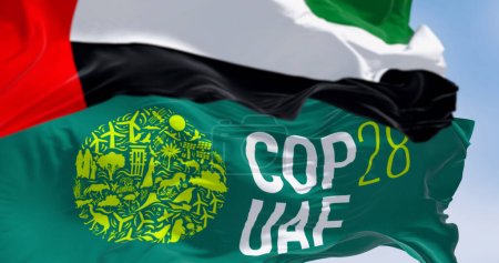 Téléchargez les photos : Dubaï, Émirats arabes unis, 30 novembre 2023 : Gros plan sur les drapeaux de la COP28 et des Émirats arabes unis par temps clair. Illustration 3D rendu. Concentration sélective. Tissu ondulant - en image libre de droit