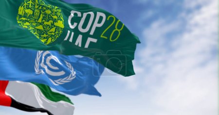 Photo for Dubai, UAE, Nov. 30 2023: Flags of COP28, UNFCCC and UAE waving on a clear day. 3d illustration render. Selective focus. Rippling fabric - Royalty Free Image